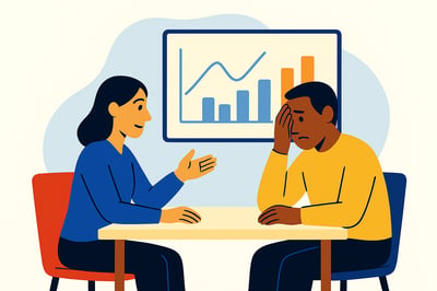A coach speaks to a client across a table. The client looks overwhelmed with his head in his hand, while the coach gestures supportively. A simple chart with line and bar graphs is displayed on a screen behind them, symbolizing progress and behavioral patterns.